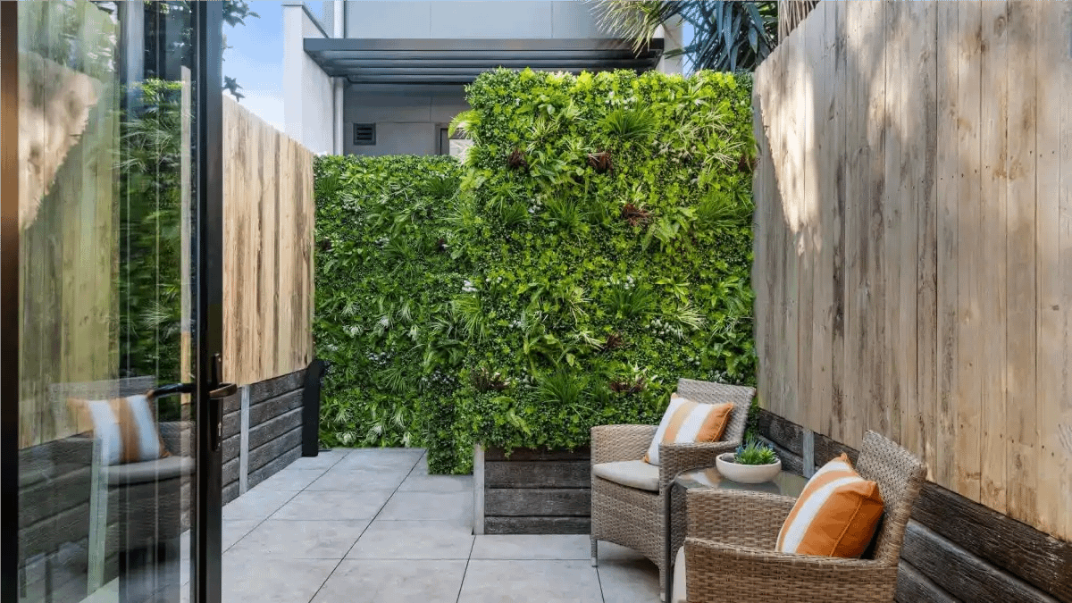 Uma parede verde com plantas híbridas feita na sala da casa. Dicas no Blog Conversa Pronta.